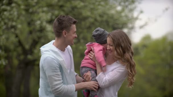 Счастливая молодая семья проводит время на свежем воздухе — стоковое видео