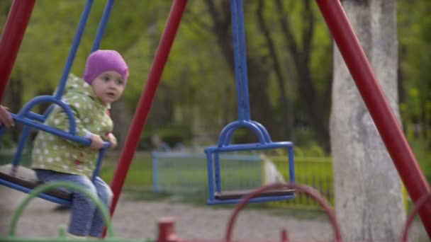 Child on swing in spring park — Stock Video