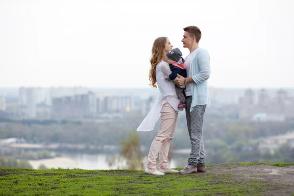 Szczęśliwa młoda rodziny na tle miasta — Zdjęcie stockowe