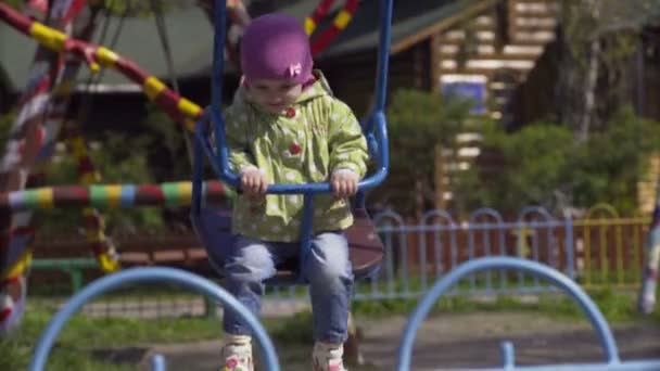 Child on swing in spring park — Stock Video