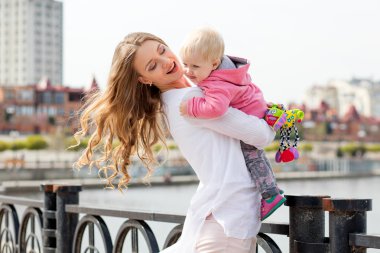 Güzel genç gülümseyen kadın kentsel arka plan üzerinde çocuk ile