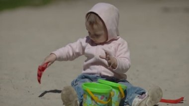 Mutlu çocuk yazın kumsalda kumla oynuyor.