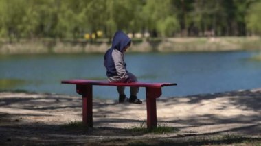 Göl kenarında bankta çocuk