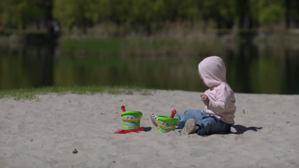 Boldog gyermek játszik homokkal a strandon nyáron — Stock videók