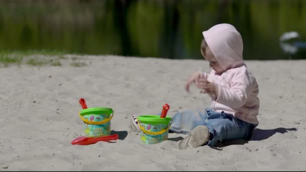 Boldog gyermek játszik homokkal a strandon nyáron — Stock videók