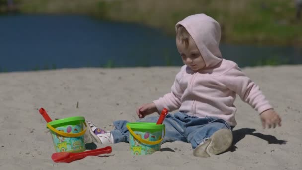 Niño feliz jugando con arena en la playa en verano — Vídeo de stock