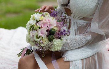 Gelin gelin buketi dizlerinin üzerinde tutan.