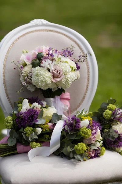 新娘在老式椅子上设置的花束 免版税图库照片