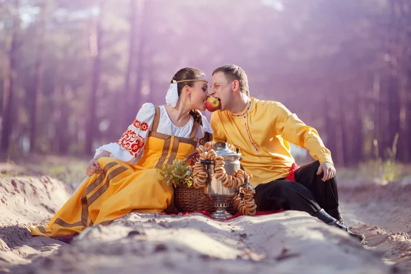 Šťastný pár v ruských národních krojích na přírodu — Stock fotografie