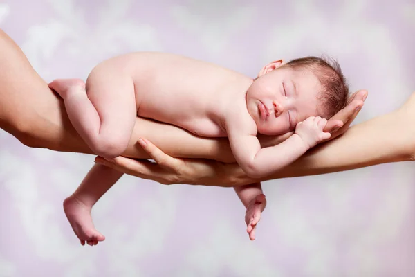 Newborn baby sleeping on parents hands — Stock Photo, Image