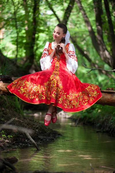 Schöne Mädchen in einem russischen Nationalkleid im Wald — Stockfoto