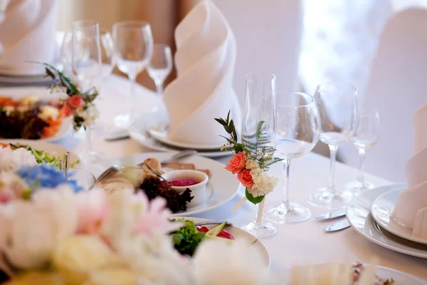 Servido para uma mesa de banquetes. Copos de vinho com guardanapos, copos e saladas. — Fotografia de Stock