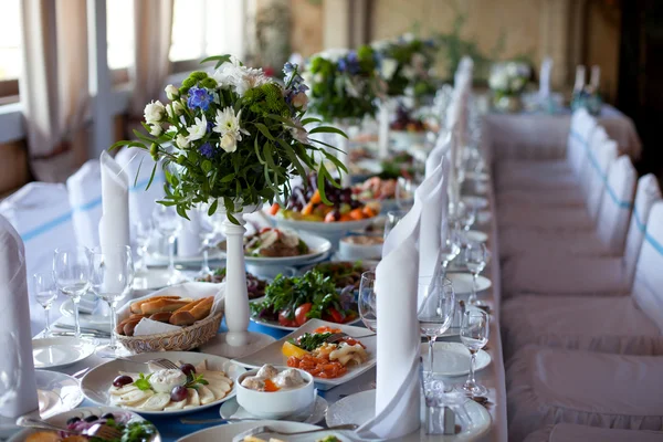 Servido para uma mesa de banquetes. Copos de vinho com guardanapos, copos e saladas. — Fotografia de Stock