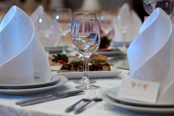 Copas de vino, servilletas y ensalada sobre la mesa para el banquete . —  Fotos de Stock