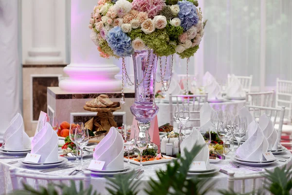 Flores, copos de vinho, guardanapos e salada na mesa para o banquete . — Fotografia de Stock