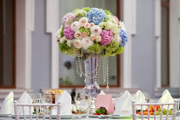 Blommor, vinglas, servetter och sallad på bordet för banketten. — Stockfoto