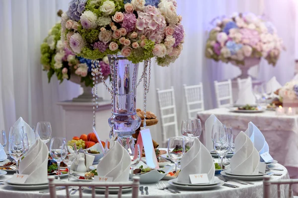 Flores, copas de vino, servilletas y ensalada sobre la mesa para el banquete . — Foto de Stock