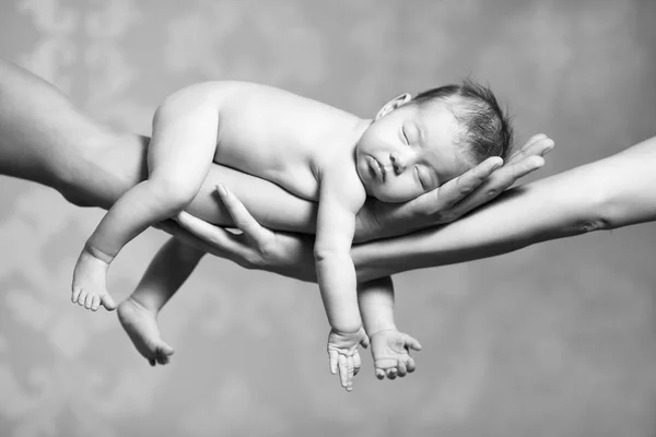 Sleeping baby on hands of parents — Stock Photo, Image