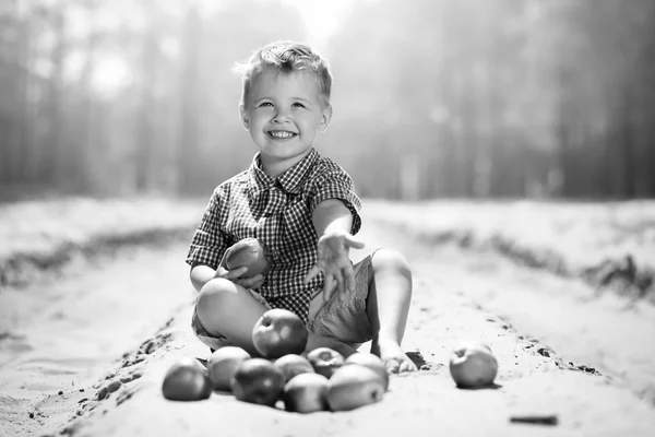 A little boy with apples on nature — Stock Photo, Image