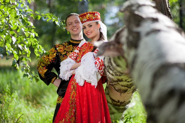Ζευγάρι στην ρωσική εθνική φόρεμα για το φόντο του δάσους — Φωτογραφία Αρχείου