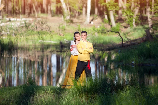 森の背景にロシア民族衣装でカップル — ストック写真