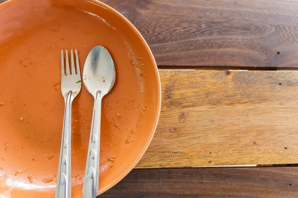 Empty dish after food on wooden table — Stock Photo, Image