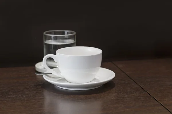 Tasse Kaffee mit Glas und Wasser auf Holztisch — Stockfoto