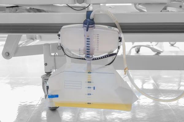 Plast urin påse hängande under patientens säng — Stockfoto