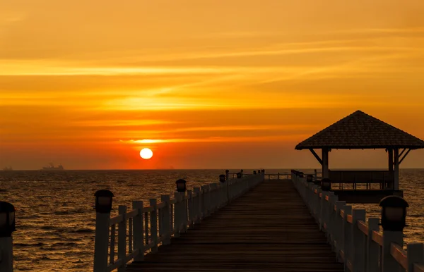 Sonnenuntergang über dem Meer mit Holzbrücke — Stockfoto