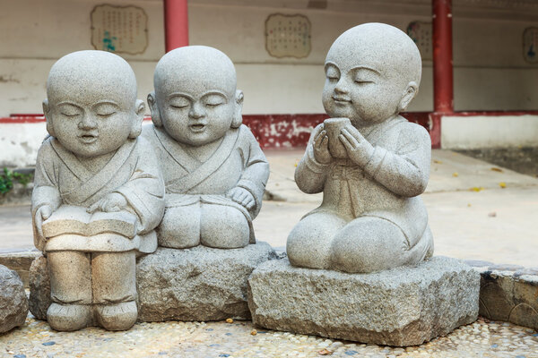 Stone statue of learning and relax Chinese monks 