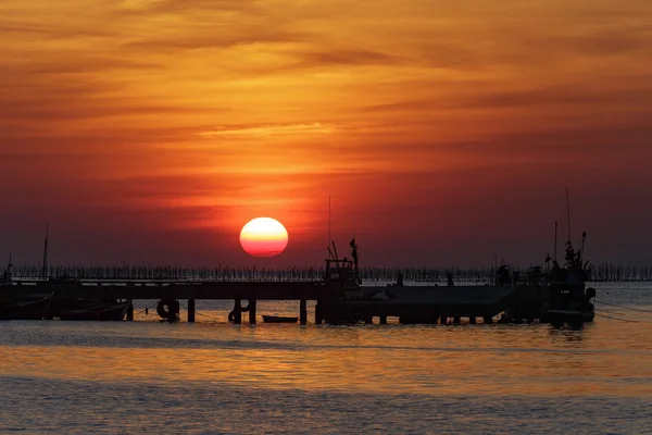 Pôr do sol sobre o mar e silhueta cais de pesca — Fotografia de Stock