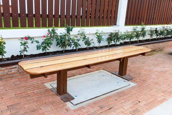 Wooden bench on footpath — Stock Photo, Image