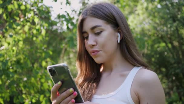 携帯電話から音楽を聴く若い美しい女性の肖像画 — ストック動画