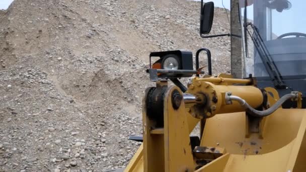 Nær et hydraulisk stempelsystem for bulldosere, traktorer, gravemaskiner, krombelagt sylinderaksel på gul maskin, detaljer om byggebransjen – stockvideo