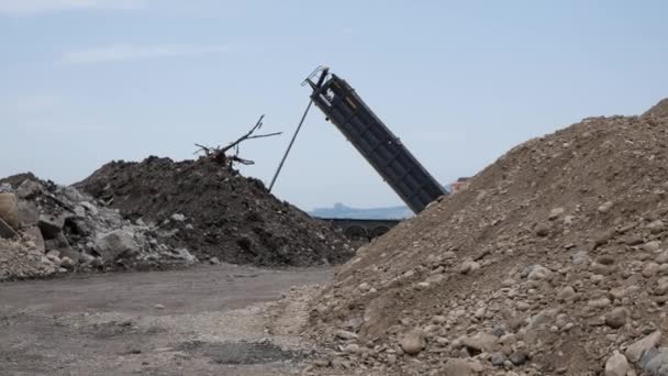 Dump truck unloading soil or ground sand from bucket at construction site. Construction machine - elevating hydraulic platform unloader unloads sand from trailer. Russia, Stavropol, 10.06.20 — Stock Video