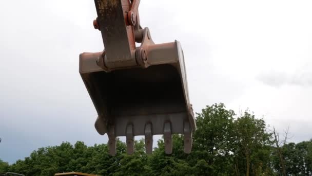 Primer plano de un cubo de excavadora levantado contra el cielo — Vídeos de Stock