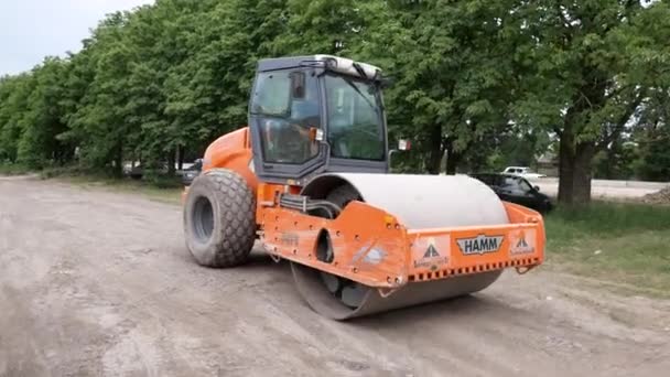 Paseos en rodillo por carretera en el sitio de construcción. Compactador vibratorio del suelo. Industrial. Rusia, Stavropol, 10.06.20 — Vídeo de stock