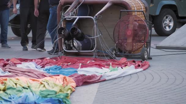 Gros plan du panier à ballon suspendu avec brûleur posé sur le sol avec bouteilles de gaz et ballon enroulé — Video