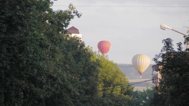 Dos globos vuelan en la distancia contra el fondo de la ciudad. Rusia, Stavropol - 29.08.20 — Vídeos de Stock