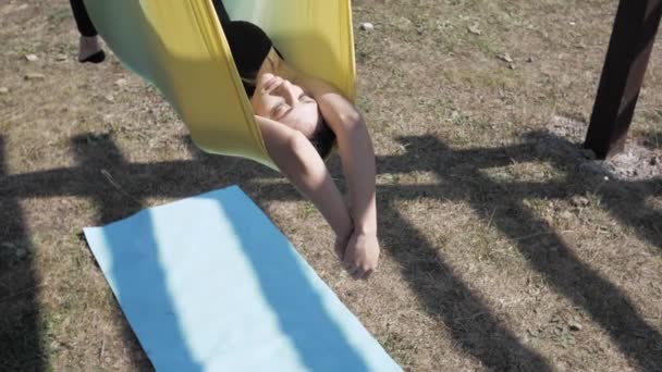 Genç bir kadın yaz günü havadan ters çevrilmiş anti-yerçekimi yogası uyguluyor. Sağlıklı yaşam tarzı ve uyum içinde yaşama kavramı. Özgürlük, nefes ve sakinlik. Yavaş çekim — Stok video