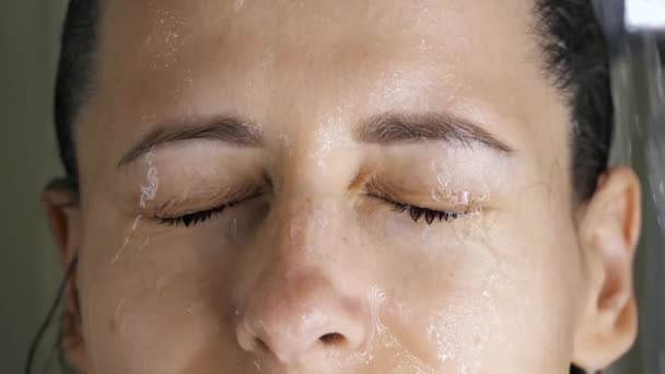 brunetka žena mytí ve sprše zalévání vlasy, tvář s vodou ze sprchy