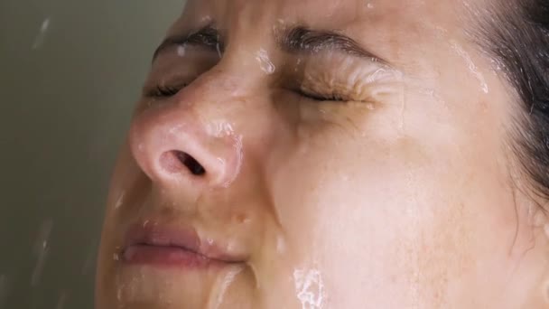 Brunette femme lavage dans douche arrosage cheveux, visage avec de l'eau de pomme de douche — Video