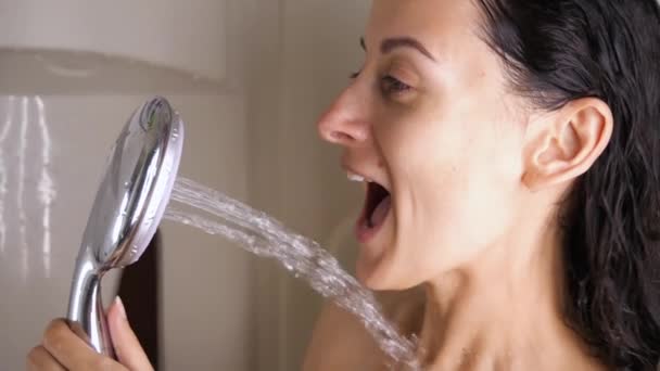Ung brunett kvinna sjunger i duschhuvud och dans medan du tar dusch — Stockvideo