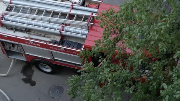 Верхній вид з вікна на рятувальну службу пожежну вантажівку з ковзною драбиною на даху. Росія, Ставрополь, 1.05.20 — стокове відео