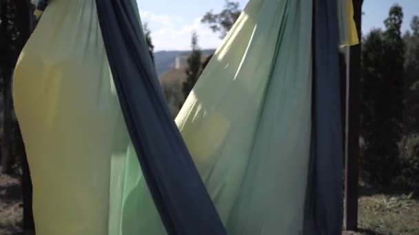 Jonge vrouw in de natuur staat met sport hangmat voor lucht yoga klassen — Stockvideo