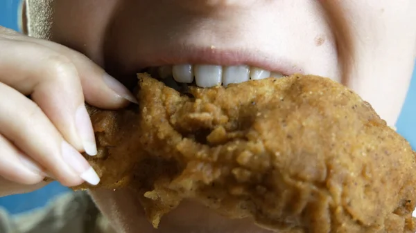 Yakın plan, güzel bir kadın fast food, tavuk nugget, kanat ve tavuk budu yer..