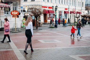 Ofis kıyafetleri içinde genç ve güzel sarışın iş kadını yağmurdan sonra şehirde yürüyor. Rusya, Stavropol - 12.04.2019