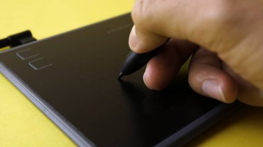 Tasarımcının görüntüsü bilgisayardaki grafik tabletine çizer.