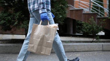 Kurye eve yiyecek getiriyor. Karantinaya yiyecek teslimatı. Evde kal.