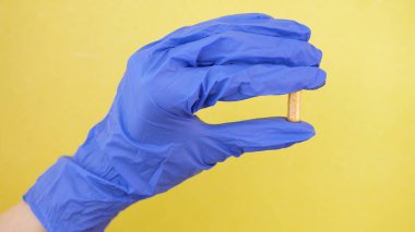 Torpido gözünde tutulan hap kapsülüne yakın çekim. Tıp çalışanı, laboratuvarda doktor. sarı arkaplanda izole.